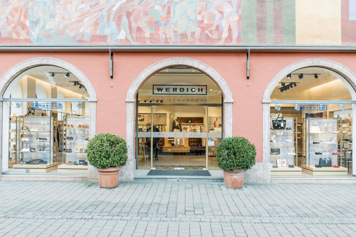 Werdich, Augsburg | Das traditionsreiche Weberhaus in Augsburg erstrahlt seit Frühjahr 2018 in neuem Glanz. Das räumliche Zentrum der Werdich-Filiale bildet eine großzügige Bar sowie ein schweres gepolstertes Ledersofa. (Foto: Werdich)