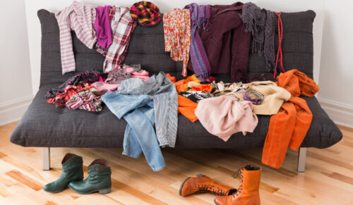 What to wear? Messy colorful clothing on a sofa.