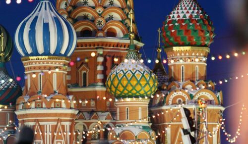 People skate on Red Square near to Saint Basil Cathedral, Moscow, Russia. Focus on temple.
