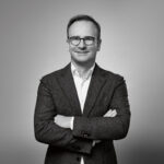 JENS BEINING: Ein klarer Fokus. Und konsequentes Handeln. Diese Tugenden zeichneten Jens Beining in den vergangenen Monaten aus. Der CEO der Wortmann Gruppe gehört nicht zu den ’Lautsprechern‘ der Branche, stattdessen arbeitet er mit seinem Team in Detmold zielstrebig an der Zukunft der Marken Tamaris & Co. Für Jens Beining stehen dabei stets die Kundinnen und ihre veränderten Ansprüche im Mittelpunkt seiner Arbeit.