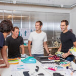 Team On: Es begann mit abgeschnittenen Gartenschläuchen. Vor zehn Jahren gründeten die drei Schweizer David Allemann, Olivier Bernhard und Caspar Coppetti die Laufschuh-Marke On. Kern der Marke ist eine neue Sohlentechnologie, die den Trägern einen besonders weichen Auftritt und trotzdem Vortrieb bieten soll. Die ersten Prototypen entstanden 2010 eben aus Gartenschläuchen. Heute hat sich On in der Branche etabliert. Und gewinnt auch im „brown-shoes“ Handel immer mehr Partner hinzu.