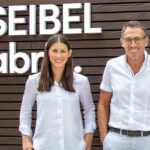 FRANZISKA UND CARL-AUGUST SEIBEL: Premiere in Hauenstein. Im „Schuhdorf“ eröffneten Carl-August Seibel, seine Tochter Franziska und deren Ehemann Michael Fischer als vierte und fünfte Generation die neu gestaltete „Gläserne Schuhfabrik“. Das Projekt ist Teil einer Neuausrichtung des Familienunternehmens, weg vom „Pfälzer Understatement“, hin zu einem modernen Branchenplayer mit klarer Markenaussage und Fokus auf Nachhaltigkeit. (Foto: Redaktion)