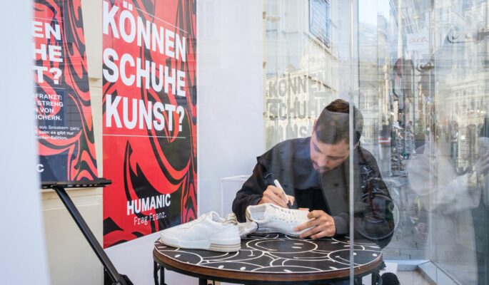 Der österreichische Künstler Max Fresh bei der Malaktion im Schaufenster. (Foto: Humanic/Manolo Ponte)