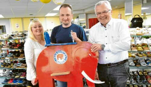 Inhaberfamilie Konle (v.l.n.r.): Monika, Daniel und Christian Konle halten zum Jubiläum das alteingesessene und beliebte Schaukelpferd in die Höhe. (Foto: Berthold Veh)
