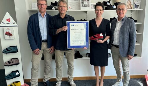 IHK-Geschäftsstellenleiter Richard Brunner (r.) und Gremiumsvorstand Josef Dischner (l.) übergeben Sarah Schubert und Martin Hübner zum 65-jährigen Jubiläum eine IHK-Ehrenurkunde. (Foto: IHK Cham)