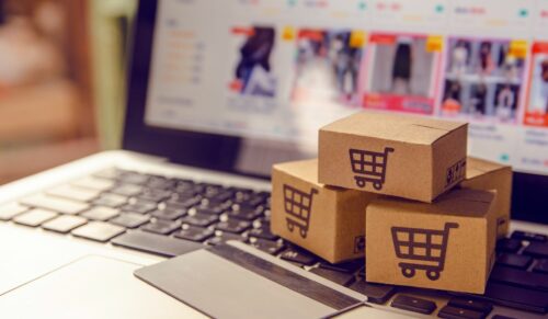 Shopping online concept - Shopping service on The online web. with payment by credit card and offers home delivery. parcel or Paper cartons with a shopping cart logo on a laptop keyboard
