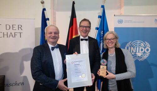 Jan Lorch (l.), Geschäftsleiter Vertrieb & CSR bei Vaude, und Hilke Patzwall (r.), Nachhaltigkeitsmanagerin bei Vaude, freuen sich mit UNIDO-Generaldirektor Gerd Müller über die Auszeichnung. (Foto: Vaude)