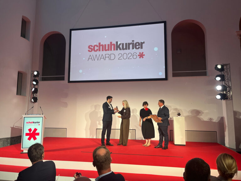 Laudatorin Elke Müller Kern übergibt den schuhkurier AWARD für den Besten Händler 2026 an Niklas Krohn, Krohn Schuhe. (Foto: Redaktion)